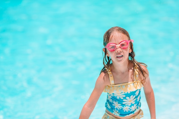 Adorable niña en la piscina al aire libre