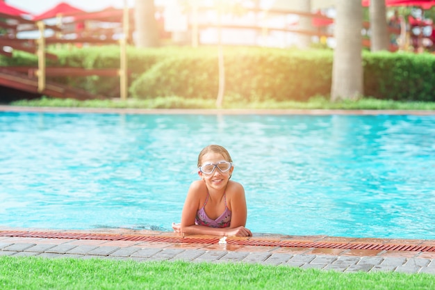 Adorable niña en la piscina al aire libre