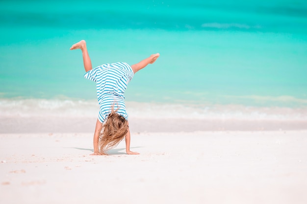 Adorable niña en la playa en sus vacaciones de verano