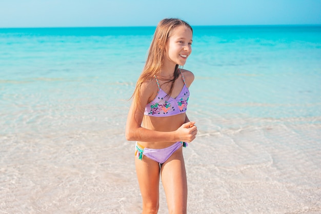 Adorable niña en la playa en sus vacaciones de verano