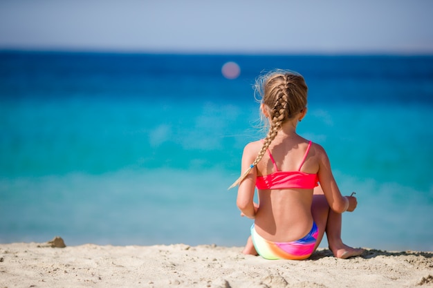 Adorable niña en la playa tropical durante las vacaciones