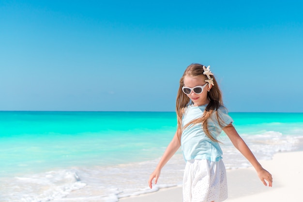 Adorable niña en playa tropical