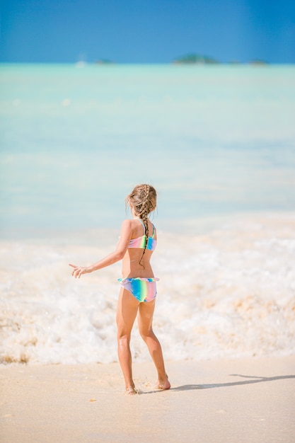 Adorable niña en la playa durante las vacaciones de verano