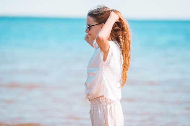 Adorable niña en la playa durante las vacaciones de verano