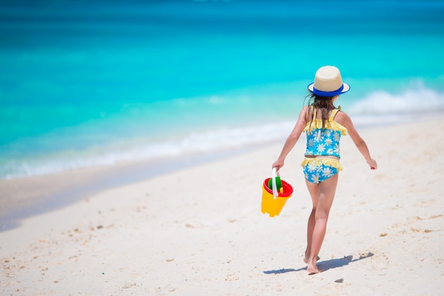 Adorable niña en la playa durante las vacaciones de verano