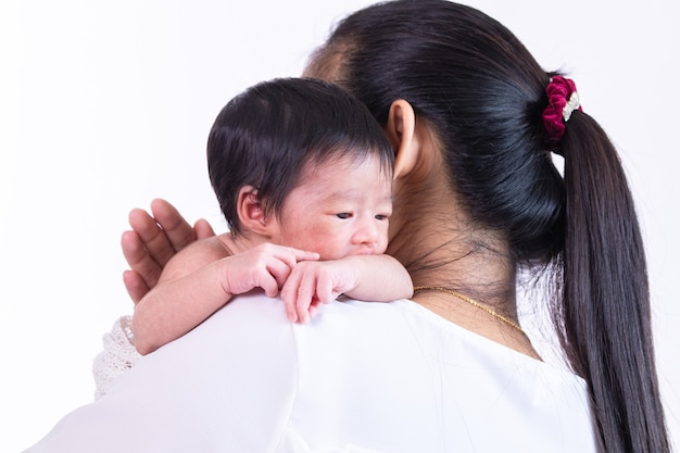 Adorable niña recién nacida se despierta en el hombro de su madre