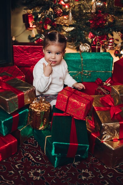 Adorable niña en regalos de Navidad. Árbol de Navidad.