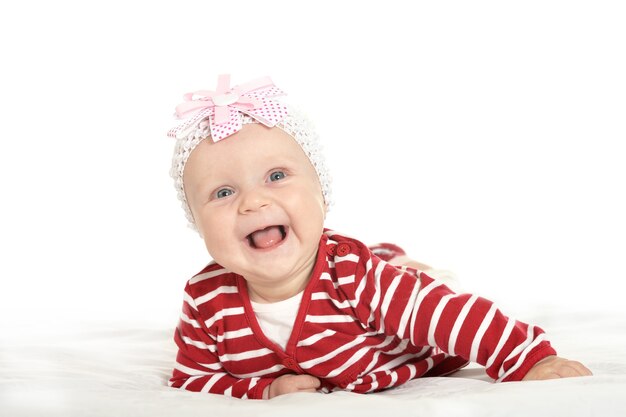 Adorable niña en ropa linda sobre un fondo blanco.