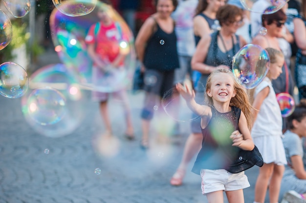 Adorable niña soplando pompas de jabón en Trastevere en Roma, Italia