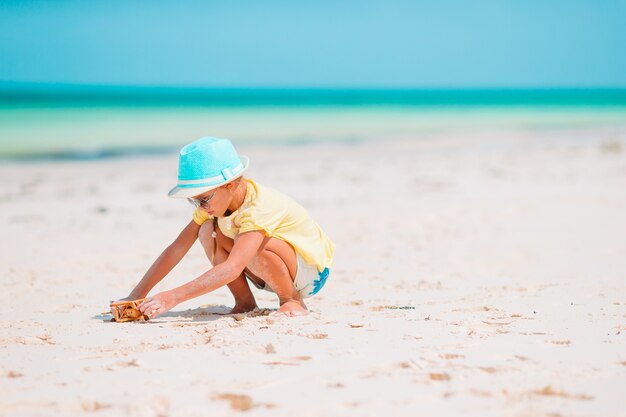 Adorable niña en traje de baño en playa tropical