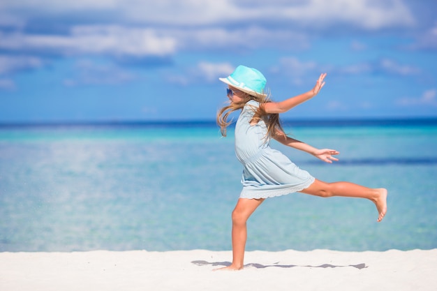 Adorable niña durante vacaciones en la playa divirtiéndose