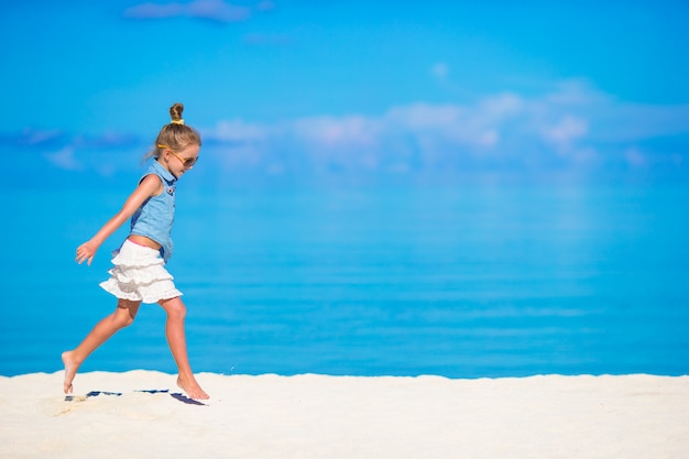 Adorable niña durante vacaciones en la playa divirtiéndose