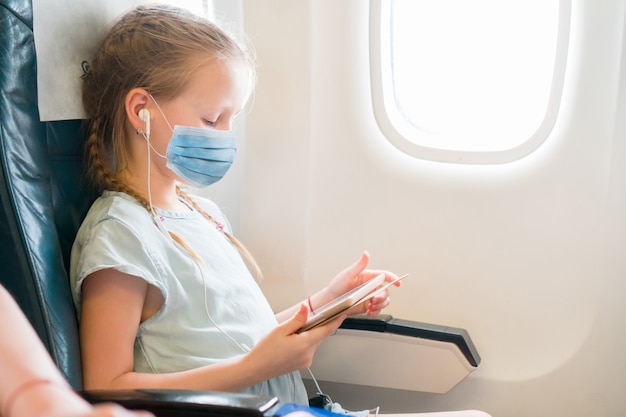 Adorable niña viaja en un avión.