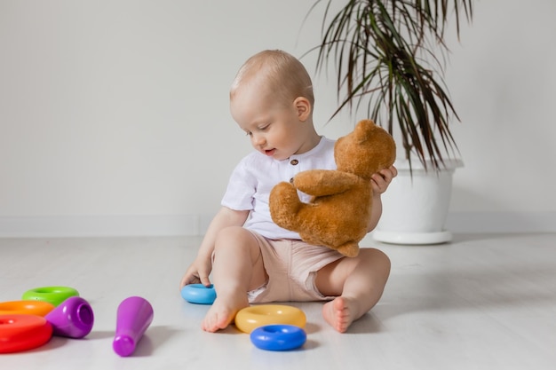 adorable niñito jugando con oso de peluche en el piso, juguetes, salud, pancarta, tarjeta, espacio para texto