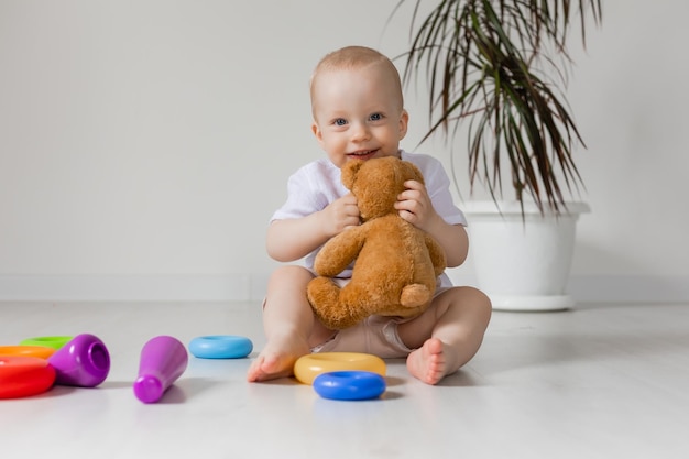 adorable niñito jugando con oso de peluche en el piso, juguetes, salud, pancarta, tarjeta, espacio para texto