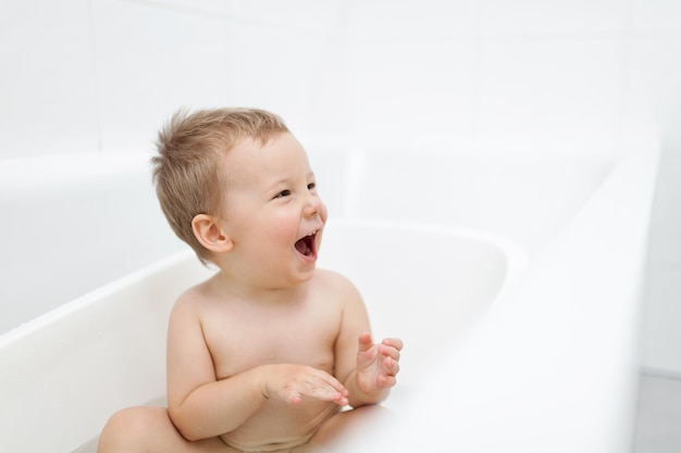 Adorable niño en el baño bañándose