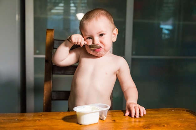 Foto adorable niño comiendo requesón con una cuchara