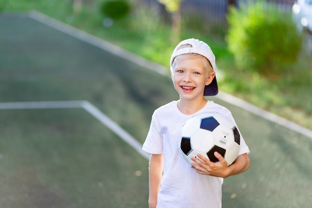 Adorable niño deportivo en el campo de fútbol