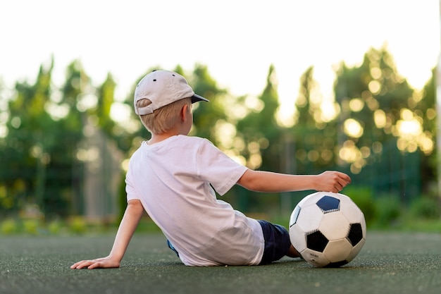 Adorable niño deportivo en el campo de fútbol