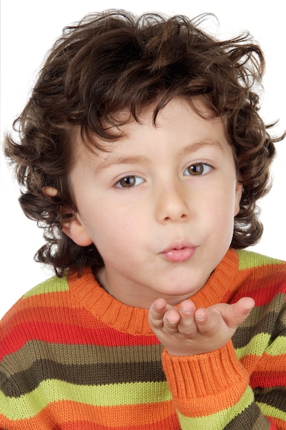 Adorable niño enviando un beso sobre fondo blanco