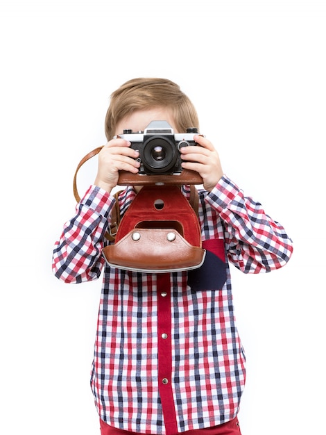 Adorable niño fotógrafo inteligente con cámara negra en las manos