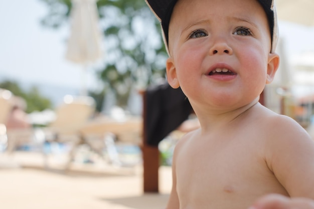 Foto adorable niño con gorra en la playa