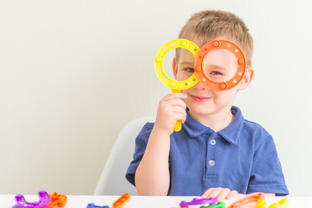 Adorable niño hecho vasos de juguete de bloque de plástico y foto horizontal de espacio de copia sonriente de divertido toddl