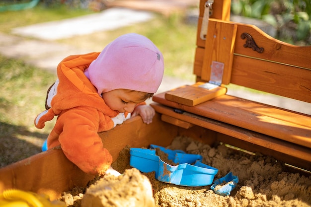 Adorable niño jugando en el arenero lindo niño en pijama de zorro juega en la arena retrato de un