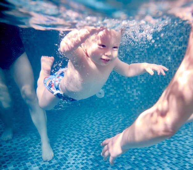 Adorable niño nadando bajo el agua