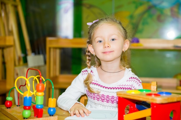 Adorable niño niña jugando con juguetes educativos en la sala de guardería