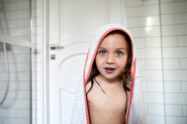 Adorable niño con el pelo mojado en el baño.