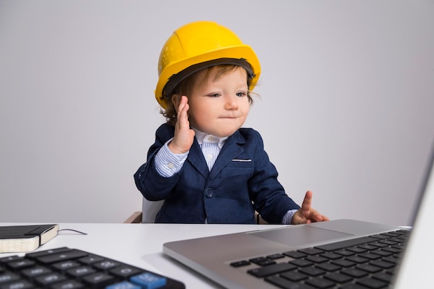 Foto adorable niño pequeño en casco de construcción amarillo