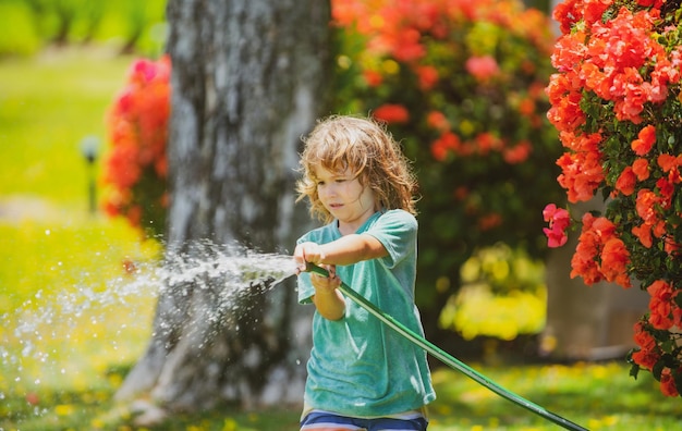 Adorable niño pequeño está regando la planta fuera de la casa concepto de actividad de aprendizaje de cultivo de plantas para la educación de niños y niños para el árbol en la naturaleza