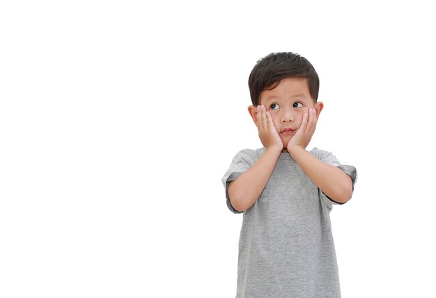 Adorable niño pequeño mirando hacia arriba aislado