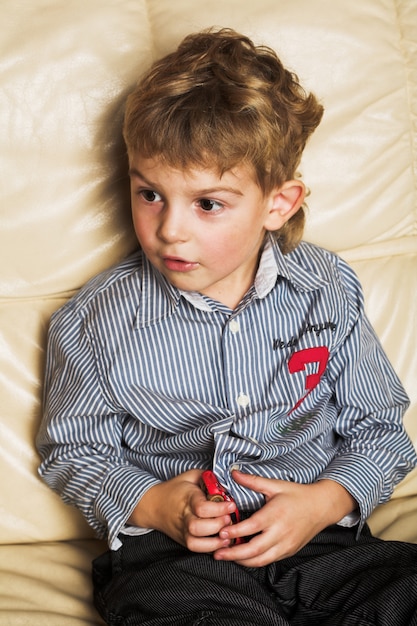 Adorable niño se sienta en el sofá