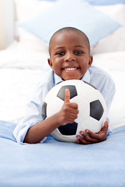 Adorable niño sosteniendo un balón de fútbol