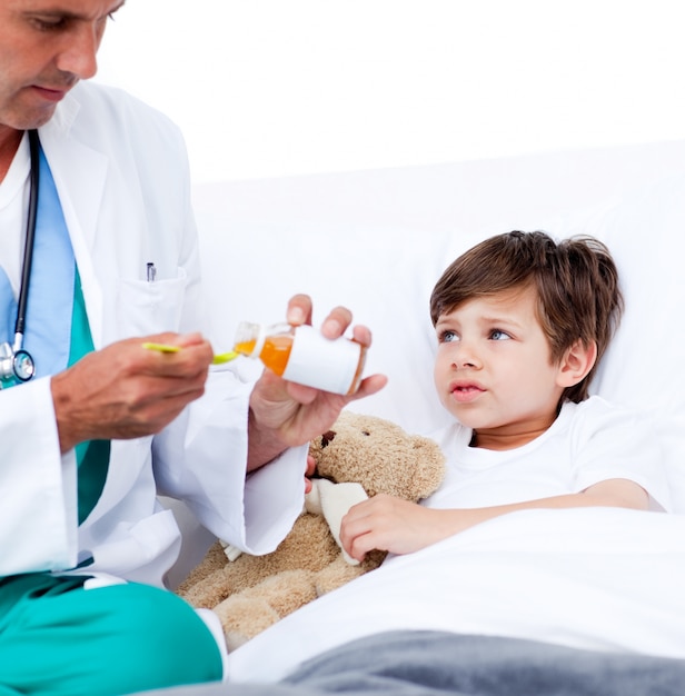 Adorable niño tomando medicina para la tos