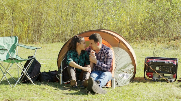 Adorable pareja joven con un dulce momento en la tienda de campaña. Par acampar en el desierto.