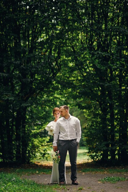 Adorable pareja de novios en el paseo en el parque el día de su boda