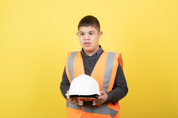 adorable trabajador de la construcción en chaleco de seguridad con casco.