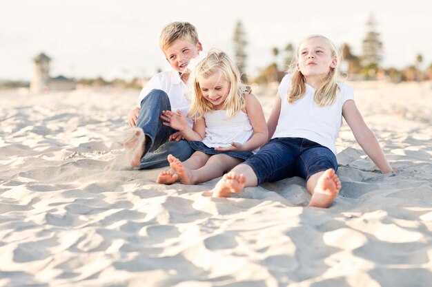 Adorables hermanas y hermanos divirtiéndose en la playa