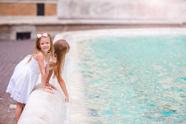 Adorables niñas cerca de la Fuente de Trevi en Roma.