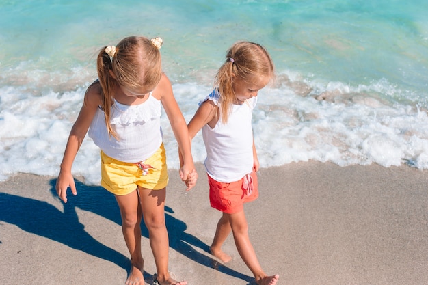 Adorables niñas se divierten juntas en una playa tropical