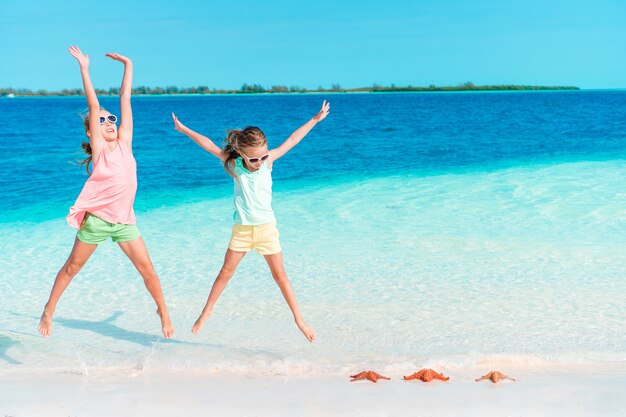 Las adorables niñas se divierten mucho en la playa.