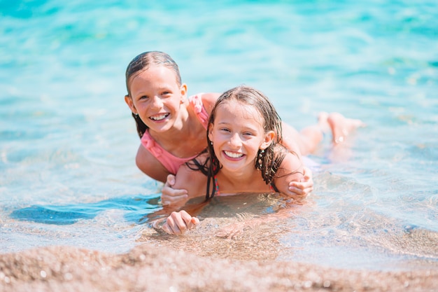 Adorables niñas divirtiéndose en la playa