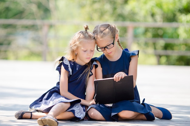 Adorables niñas de la escuela al aire libre en un cálido día de septiembre. de vuelta a la escuela.