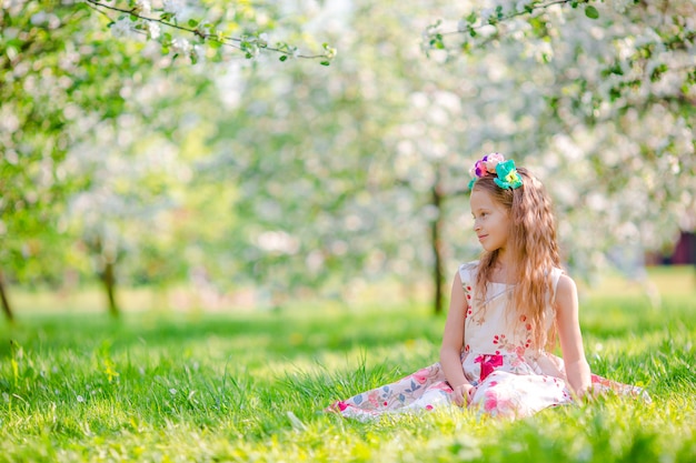 Adorables niñas en jardín floreciente de manzano en primavera