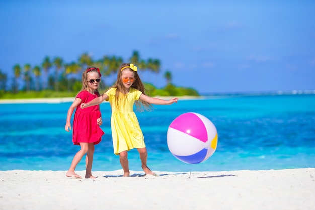 Adorables niñas jugando en la playa con pelota