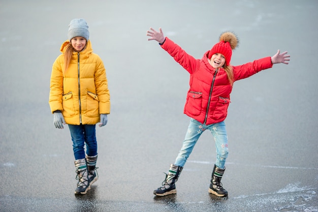 Adorables niñas patinando en la pista de hielo