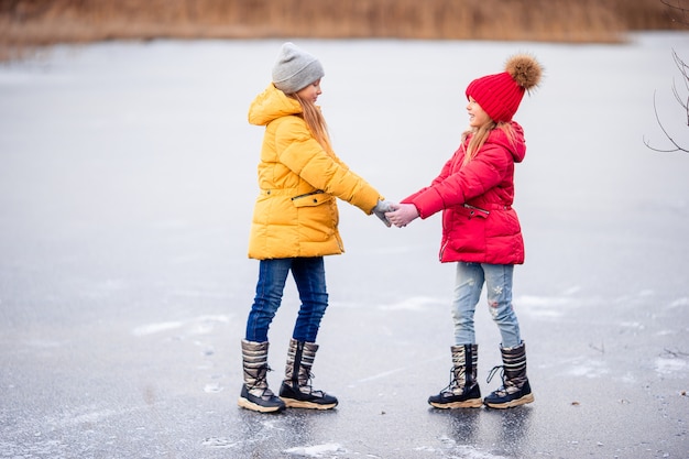 Adorables niñas patinando en la pista de hielo